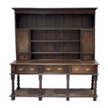 An 18th Century oak dresser, set-back closed plate rack incorporating two cupboards and short