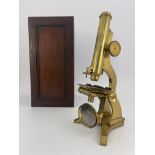 A 19th Century lacquered brass monocular microscope, signed on the tripod base by retailer J.