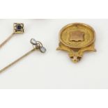 Two gold and gem set stick pins and a 9 carat gold fob medal, the pins set with aquamarine and pearl