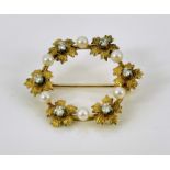 A gold, diamond and pearl wreath brooch, circular form with diamond centred flowers