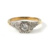 An Art Deco gold and diamond ring, the central stone in white metal setting flanked by stepped