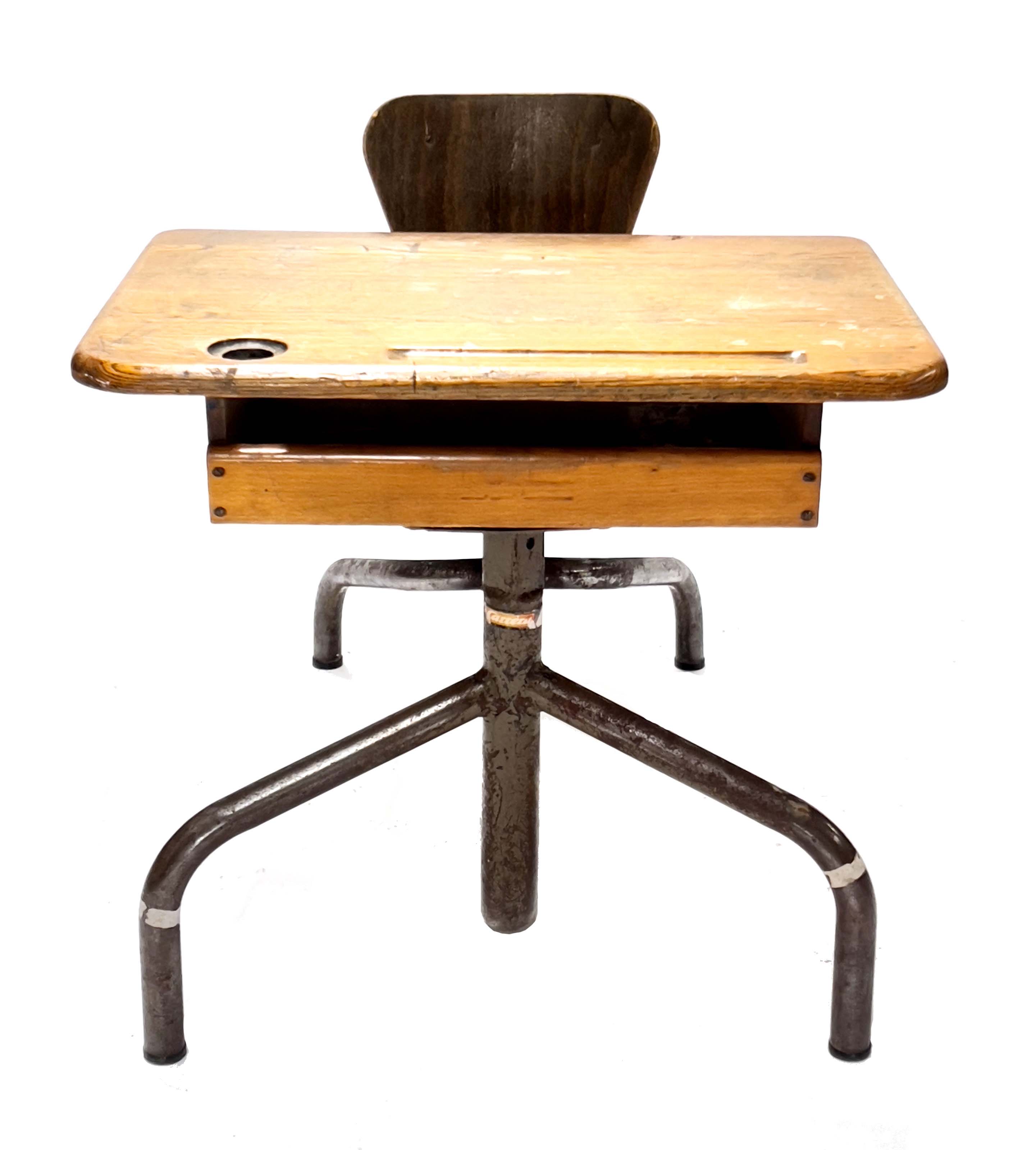 A French child's school desk, early 20th Century, oak top with ink pot hole, pen well and shelf