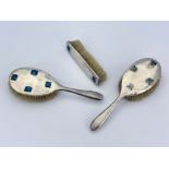 Archibald Knox for Liberty and Co., a set of three Arts and Crafts silver and enamelled brushes, Bir
