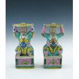 A pair of Chinese coloured enamel porcelain candle holders, in the form of smiling bearded men in