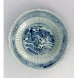 Four Oriental blue and white dishes and plates, including relief moulded lotus dish, 17th century