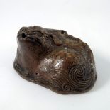 A Chinese stoneware water dropper, Ming dynasty, modelled as a recumbent Buddhist lion or foo dog,