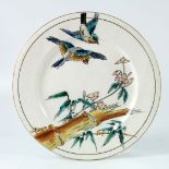 An Aesthetic Movement enameled plate, decorated in Oriental style with birds and bamboo, disguised