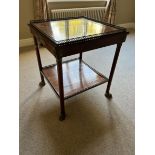 A square mahogany occasional table of Empire design, two tiers with fretwork metal galleries,