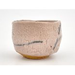 A Japanese Shino ware tea bowl, pitted cream glaze with brush work motifs, incised marks, 12cm wide
