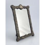 A Victorian silver framed mirror, Henry Matthews, Birmingham 1899, rectangular cartouche form, the