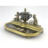 A late 19th Century brass desk inkstand, champleve enamel twin handled ink vessel with brass