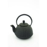 A Japanese cast iron tea pot, 19th Century, of lobed ovoid form, loop handle, cast two character