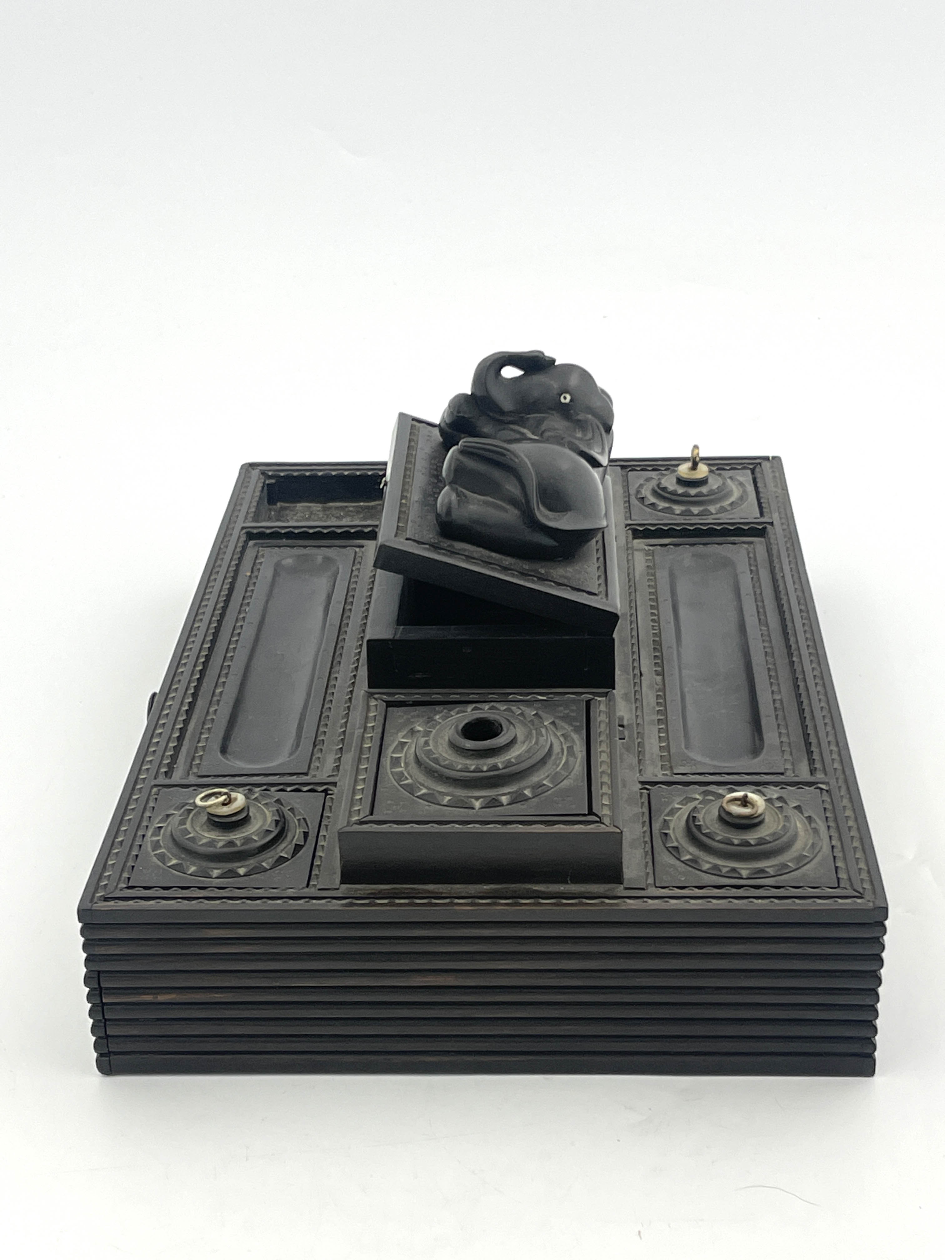 An Anglo-Indian ebony desk stand, late 19th Century, reclining elephant finial, double pen, ink - Image 4 of 5