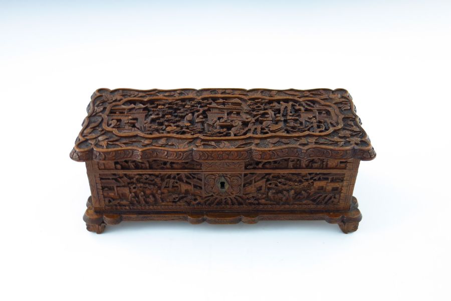 A late 19th Century Cantonese wooden table casket, carved throughout with figures and pagodas in