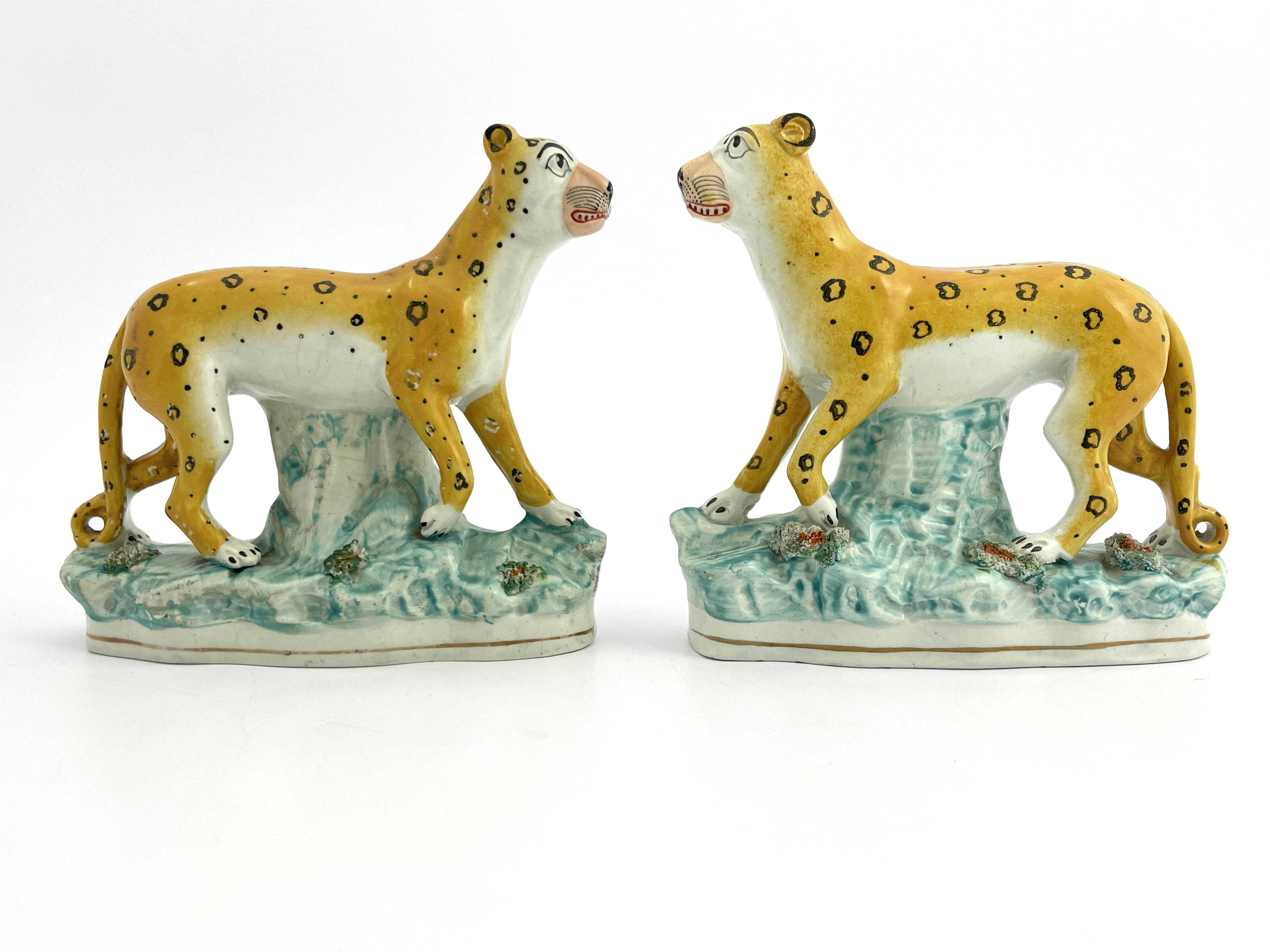 A rare pair of 19th Century Staffordshire pottery leopards, modelled strolling and decorated in