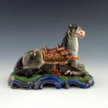 A 19th Century Paris porcelain inkwell, in the from of a recumbent horse wearing a saddle cloth,