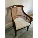 A Regency simulated rosewood library bergere armchair, circa 1820, curved back, upholstered seat,