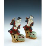 A pair of 18th Century Chinese porcelain figurines, modelled as joyful and playful boys upon a stump