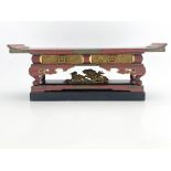 A Chinese black and red lacquer stand, early 20th Century, raised on scroll feet upon a double