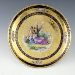 A late 19th Century Vienna porcelain concave circular charger, over-painted transfer printed