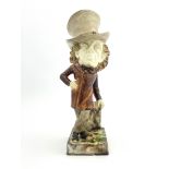 Whitman & Roth, a Staffordshire majolica figure of Disraeli, modelled sanding beside a plinth,