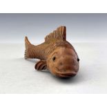 An oriental carved treen model of a fish, realistic fins and gills, glass bead eyes, signed, 16.