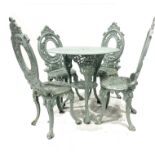 A set of four Victorian cast iron garden chairs, oval openwork backs with scroll pediments, scroll