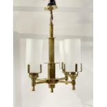 An Art Deco brass four branch chandelier, multifaceted tubular construction with frosted glass