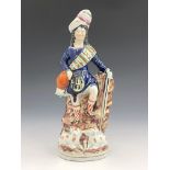 A 19th Century Staffordshire pottery figure of a Scottish shepherd, modelled wearing a sporran and
