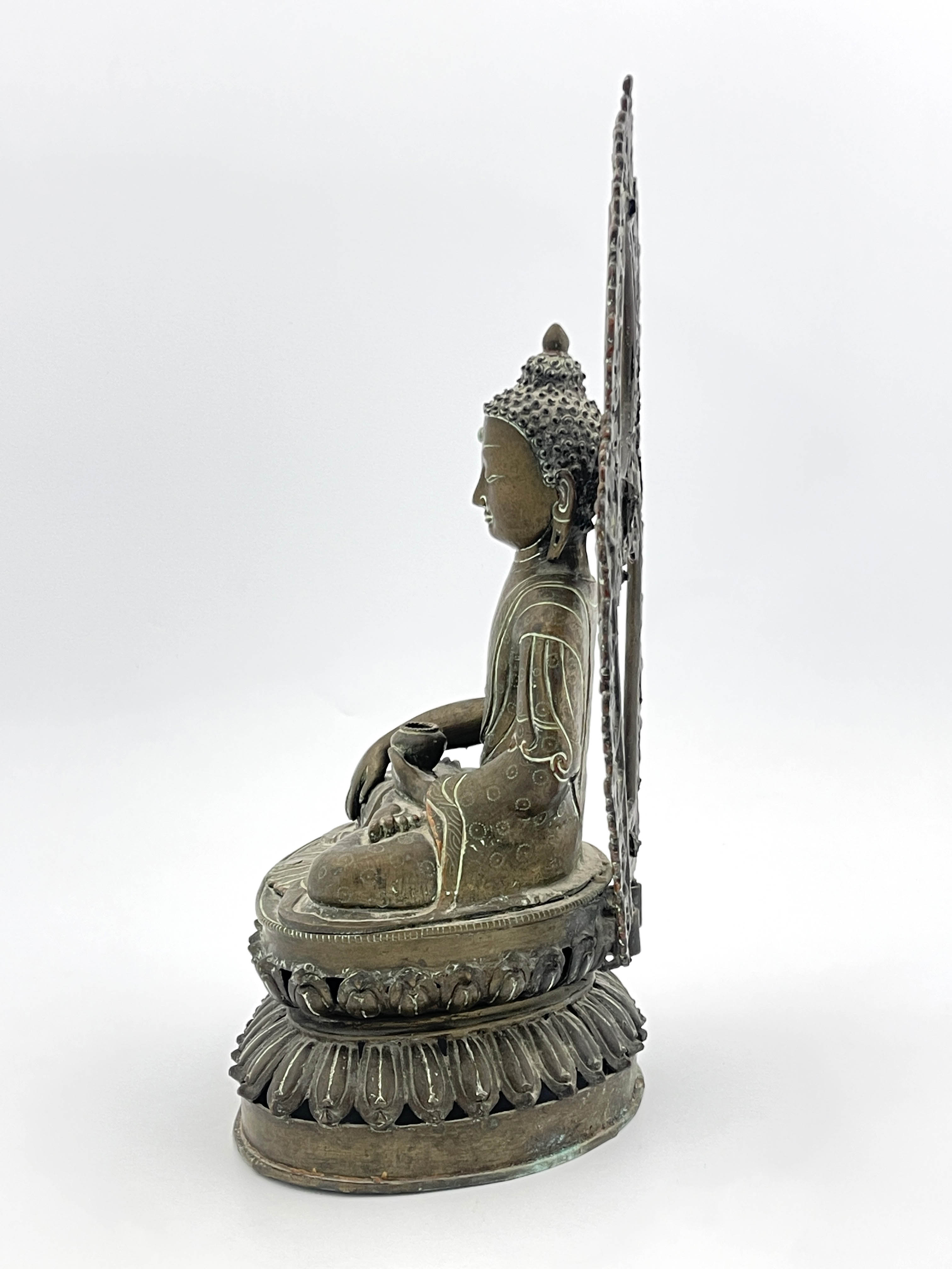 A Nepalese bronze figure of Guanyin, 19th Century, seated cross legged in front of an openwork, - Image 2 of 6