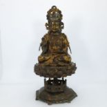 A large Chinese gilt bronze figure of a deity, seated cross legged and wearing a headdress,