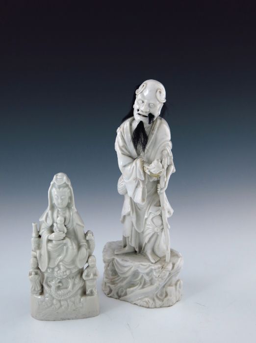 A 19th Century Chinese blanc de chine figure, modelled as a standing elder with a wooden staff,