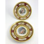 A pair of late 19th Century Vienna porcelain circular concave plaques, over-painted transfer