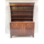 A George III country oak dresser, circa 1800, plate rack, moulded top, triple frieze drawers, with