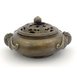 A Chinese bronze censer, twin bat handles, the base bearing four character marks, pierced bronze