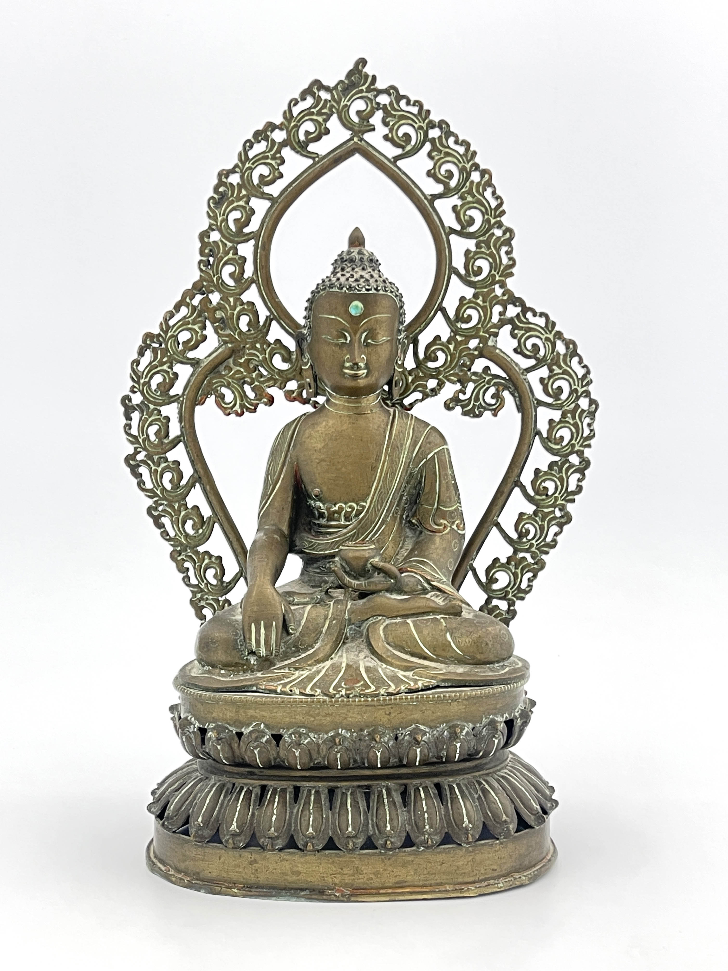 A Nepalese bronze figure of Guanyin, 19th Century, seated cross legged in front of an openwork,