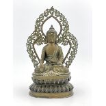 A Nepalese bronze figure of Guanyin, 19th Century, seated cross legged in front of an openwork,