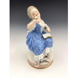 A 19th Century Meissen figure of a lady, seated on a steel with footstool wearing a blue floral