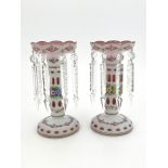A pair of ruby opaque cased glass lustres, mid 20th Century, gilt wavy rims, painted with bunches