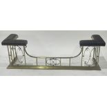 An Edwardian brass club fender, studded fabric upholstered seats, scrollwork decoration to the