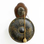 An Edwardian wall mounted dinner gong, in the from of a cast brass eagle head clutching a serpent in