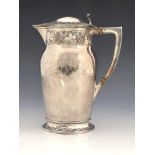 An Arts and Crafts silver plated copper wine jug, oval section shouldered form, embossed in relief