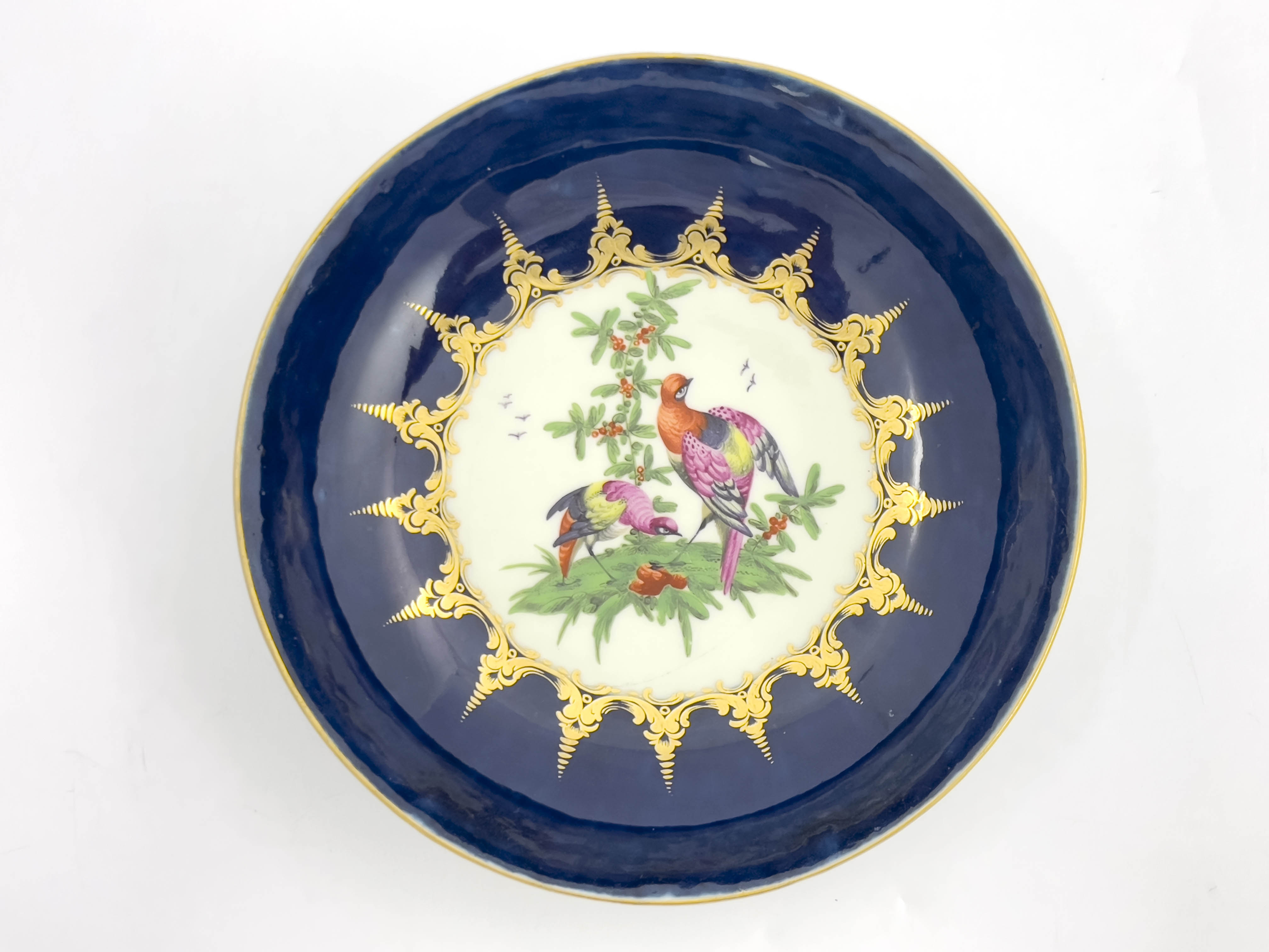 A Worcester blue ground/wet blue shallow dish, circa 1770s, decorated with fancy birds to the