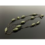 A silver and jade necklace, single strand necklace set with oval jade beads, with silver clasp and