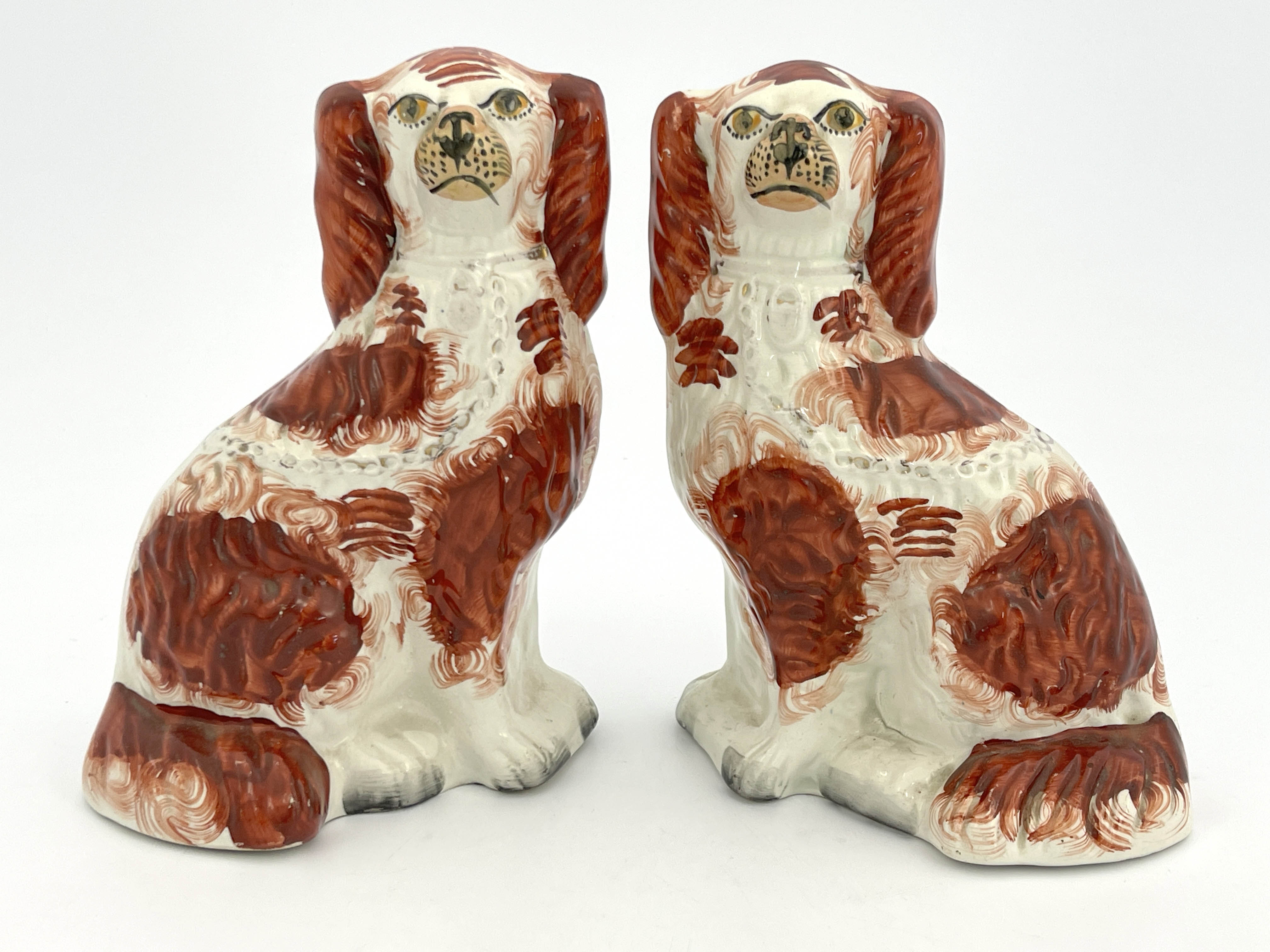 A pair of 19th Century Staffordshire flatback chimney dogs, modelled as brown and white spaniels,