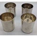 A set of 4 Arts and Crafts 20th century silver beakers, planished finish, Britannia marks, maker
