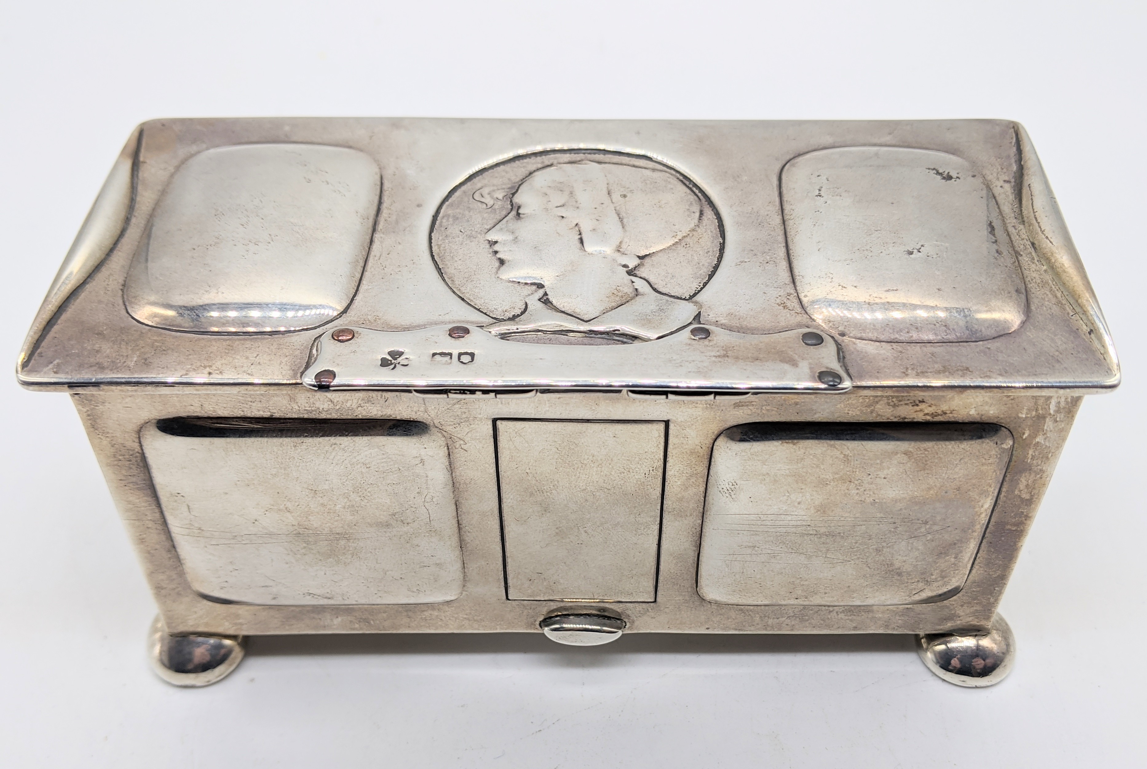 An Arts and Crafts silver box, designed by Kate Harris, the lid with embossed ladies head,