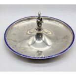 A Japanese silver dish depicting landscape scenes, central figural finial and blue enamel Greek