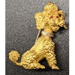 An 18ct gold poodle brooch with ruby eyes, marked to back and pin, 7.7g, H.3cm
