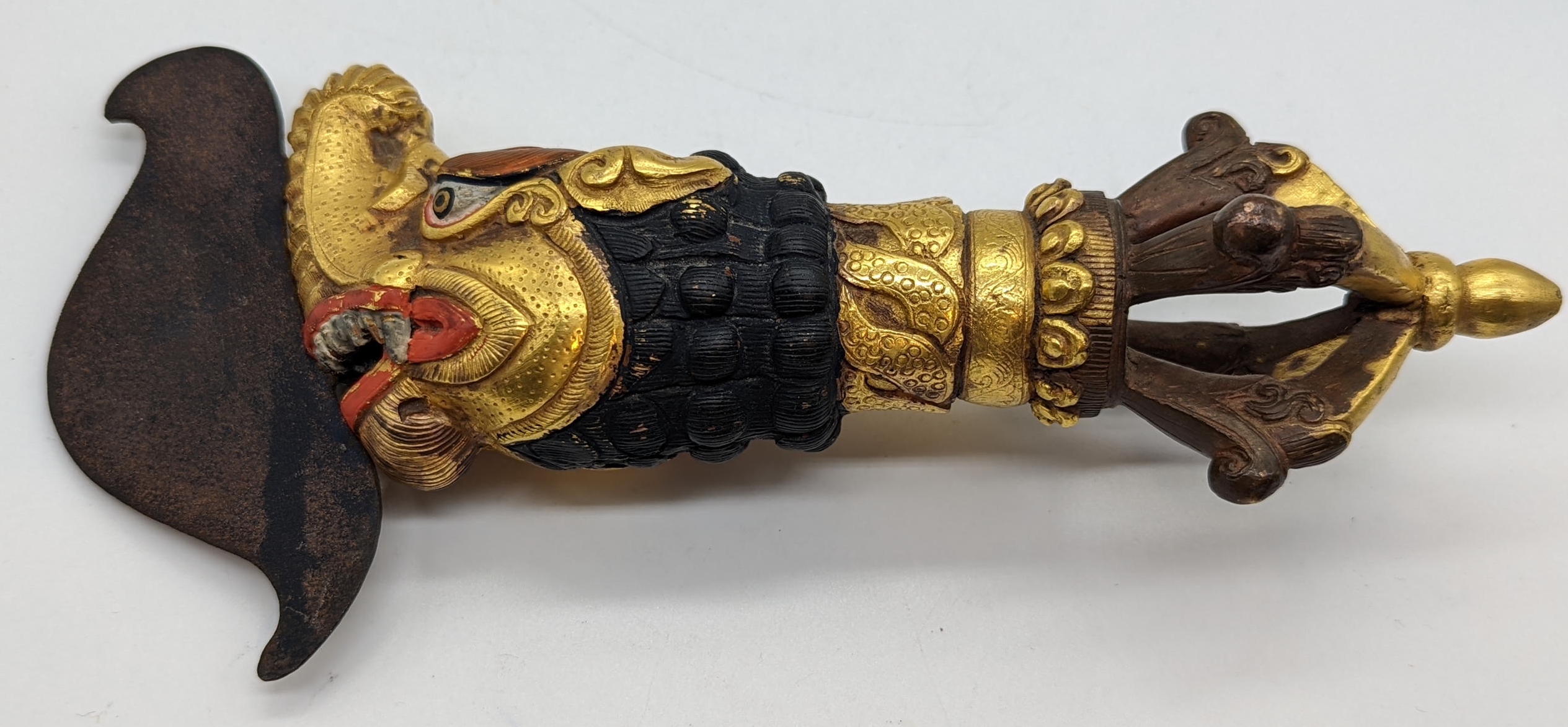 A Tibetan or Mongolian bronze ritual gilt flaying kartika with dragons head handle, L.23cm